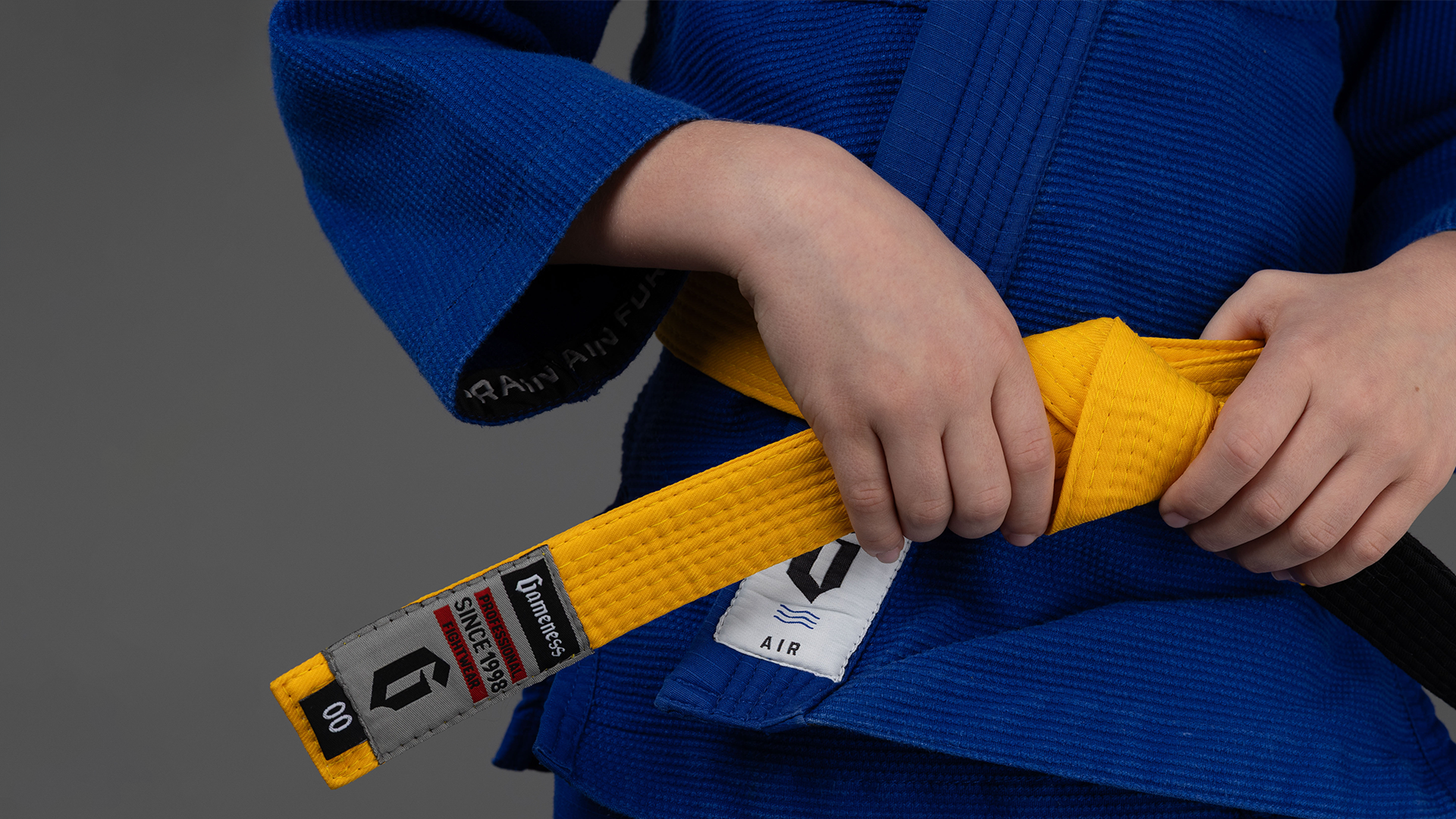 Close up Shot of Gameness Yellow Belt on Young Jiu Jitsu athlete in Blue Gameness Gi