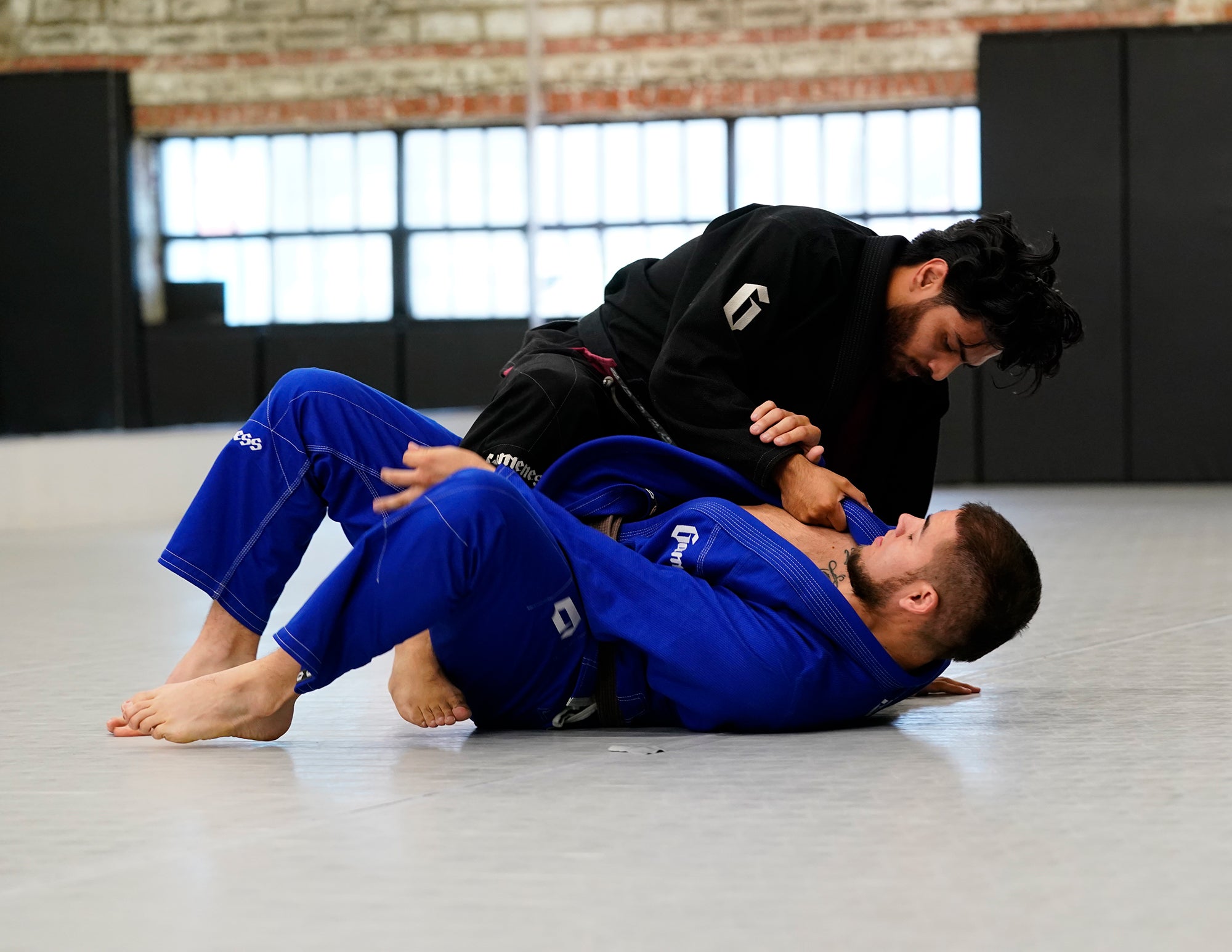 martial artists grappling on BJJ mat